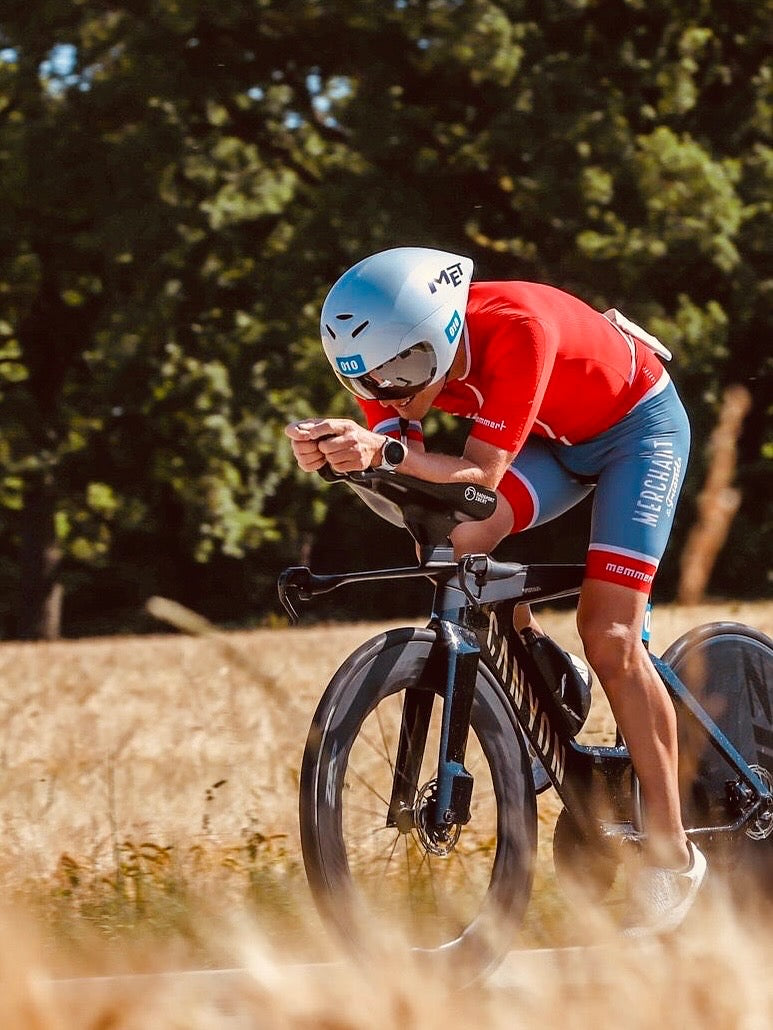 Matthias Grosser in Aeroposition auf dem Zeitfahrrad im Merchant-Triathlon-Trikot beim Rennen – Merchant & Friends Friend